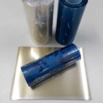 imagem com 3 rolos de Filme DTF UV visto de perto e folhas de filme DTF UV